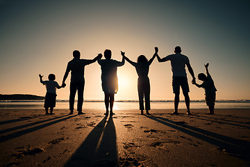 Image showing Silhouette, beach and family holding hands in sunset on a holiday or vacation at sea or ocean together. Travel, love and shadow of people celebrate in support, freedom and bonding at night or evening