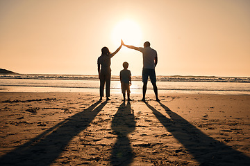 Image showing Family silhouette at beach, protection and sunset with people, safety and security with parents and child outdoor. Mother, father and kid in nature, back and ocean view with love, care and support