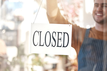 Image showing Closed, sign and happy man at shop, store and notice of retail closing time, board and advertisement. Closeup of employee advertising end of business to public, signage or information on glass window