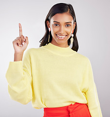 Image showing Woman with smile in portrait, pointing with marketing and product placement on studio background. Indian female, happy with promotion and advertising, direction or choice with hand gesture and deal