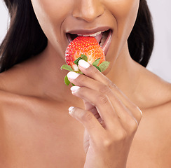 Image showing Woman, diet and studio with strawberry, mouth and eating for wellness with beauty, vegan snack and health. Model, food and nutrition with biting fruit, cosmetic and seductive closeup on background