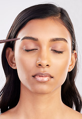 Image showing Woman, face and eyebrow pencil with makeup and beauty, eyes closed and cosmetics product on studio background. Cosmetology, facial and skin grooming for young Indian female, eyeliner or cosmetic care