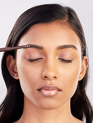 Image showing Woman, face and eyebrow pencil with beauty, makeup and eyes closed for cosmetics product on studio background. Microblading, facial or skin grooming for young Indian female, eyeliner or cosmetic care