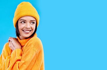 Image showing Happiness, thinking and woman with fashion and mockup in studio in cold weather with winter hat. Isolated, blue background and mock up with a happy young and gen z person with a smile, beanie and joy