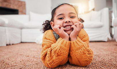 Image showing Child, portrait and girl kid lying on the floor in a home lounge or living room resting with a smile, happy and excited. Cute, relax and adorable of a young little female feeling happiness