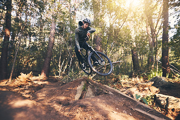 Image showing Cycling trick, speed and man on a bicycle on a dirt forest road doing training and exercise on a bike. Fast, outdoor trail and biker athlete with cardio and energy on a biking adventure with jump