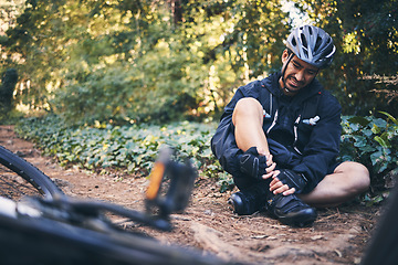Image showing Man cycling, leg injury and pain outdoor on mountain bike or bicycle in nature. Athlete cyclist person on ground in forest for fitness exercise, sports training or workout accident, crash or fall