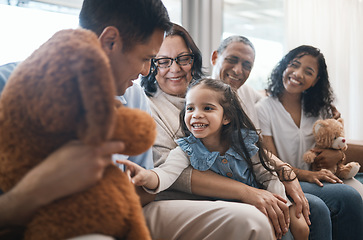 Image showing Big family, parents and girl with teddy bear on couch, grandparent and smile for game in home living room. Men, women and female child with toys, love and happiness on lounge sofa in house on holiday