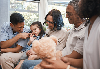 Image showing Love, children and teddy bear with a family on the sofa in the living room of their home together during a visit. Parents, grandparents and kids in the lounge of a house for bonding or relaxing