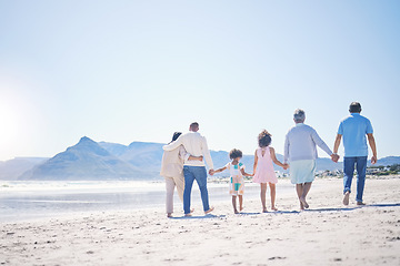 Image showing Holding hands, back and big family at the beach for walking, holiday and summer weekend by the ocean. Affection, support and parents, children and grandparents on a walk by the seaside for bonding