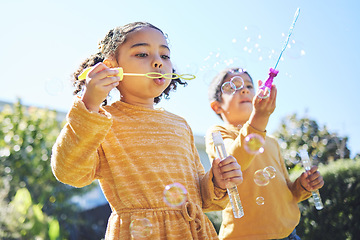 Image showing Playing, garden and children blowing bubbles for bonding, weekend activity and fun together. Recreation, outdoors and siblings with a bubble toy for leisure, childhood and enjoyment in summer