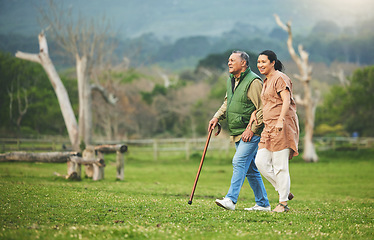 Image showing Senior couple, walking and outdoor in nature with love, support and commitment to happy partner. Elderly man and a woman on a grass field or countryside for travel, adventure and retirement vacation