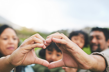 Image showing Family, heart and hands outdoor in nature for quality time, love and care outdoor. Man, woman and kids with emoji, icon or sign at a park on vacation, holiday or travel trip for bonding and support