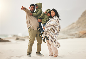 Image showing Family, children and parents at the beach in winter for quality time, love and care outdoor in nature. Man, woman and kids on a vacation, holiday or travel trip for bonding and pointing at sea