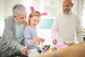 Image showing Easter, art and a girl painting with her grandparents in their home for love, bonding or celebration together. Family, kitchen or egg with a senior couple and their grandchild in a house to paint