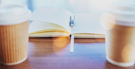 Image showing Notebook, coffee or planning with cups, a pen and a book on a table or desk in an empty office boardroom. Business, meeting and strategy with still life stationery on a wooden surface in a workplace