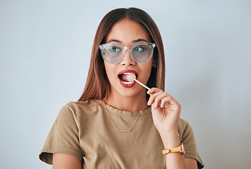 Image showing Thinking, face and woman with lollipop, glasses and confidence against a white studio background. Female, sweet and person with funky eyewear, candy and wonder with thoughts, daydreaming and decision