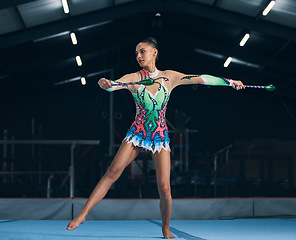 Image showing Woman, gymnastics and sticks in gym for training, dancing and performance with creativity, balance and wellness. Female gymnast, athlete and dance for workout, sports and prepare for competition