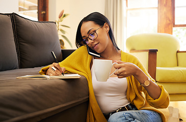 Image showing Woman, phone call or remote work with writing notes, coffee and planning schedule. Couch, mobile discussion and talking female thinking on living room floor, working from home and notebook for agenda