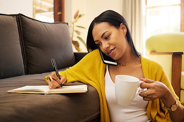 Image showing Phone call, coffee and woman writing in notebook in home on sofa for notes, research and conversation. Cellphone, book and female person talking or speaking with contact for information in lounge.