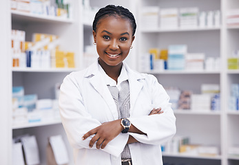 Image showing Pharmacy, pharmacist or portrait of black woman with arms crossed or smile in healthcare drugstore or clinic. Face, hospital or happy doctor smiling by medication or medicine on shelf ready to help