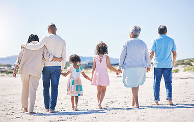 Image showing Holding hands, back and big family at the beach for holiday, walking and summer weekend by the ocean. Affection, support and parents, children and grandparents on a walk by the seaside for bonding