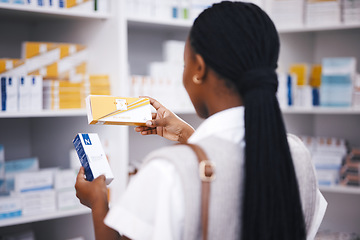 Image showing Pharmacy stock, woman and medicine check of a customer in a healthcare and wellness store. Medical, inventory and pharmaceutical label information checking of a black female person back by shop shelf