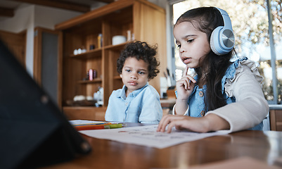 Image showing Girl child, homework and thinking with headphones, music or little brother at desk in family home. School kids, study or confused with document for assessment, test or focus for education development