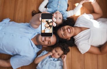 Image showing Smile, happy family on floor and selfie from above with love, bonding and quality time together. Mom, dad and kids taking picture for social media, happiness and fun, parents with children in home.