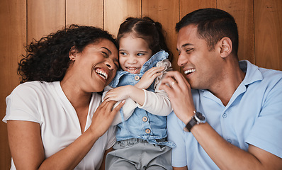 Image showing Love, funny and family with girl, parents and hug with bonding, quality time and happiness. Mother, happy father and daughter with dad, mama and female child embrace, laughing and support at home