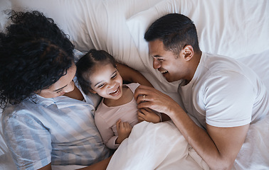 Image showing Mom, dad and child laugh in a bedroom bed in the morning at family home with bonding. Tickle, mother and father with a young girl being playful and happy with a smile and youth together with love