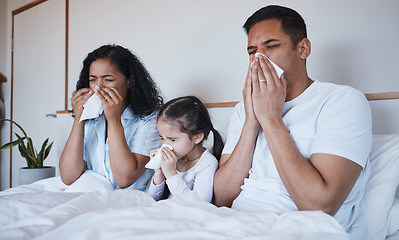 Image showing Sick, family and blowing nose in bed in home lying in bedroom together in house. Flu, parents and child wipe with tissue with man, woman and girl with covid, virus or cold, disease or winter allergy