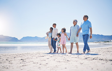 Image showing Family, holding hands and walking at beach for mockup space by sea, sand or bond with love on summer vacation. Men, women and children for support, holiday and ocean mock up with waves in sunshine