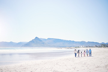 Image showing Family, beach and holding hands with mockup space by blue sky, walking and bonding with love in summer holiday. Men, women and children for support, vacation and ocean mock up with waves in sunshine