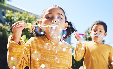 Image showing Boy, girl and playing with bubbles outdoor in garden, backyard or park with happiness, family or siblings. Children, soap bubble game and playful in childhood, youth and summer sunshine on holiday