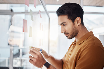 Image showing Business man, sticky note and planning on glass board, writing and focus in startup workplace. Young businessman, moodboard and brainstorming with research, goals and ideas for solution in office