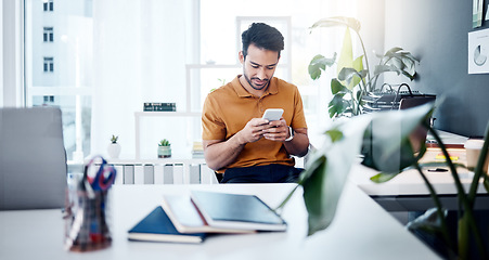 Image showing Man with smile, phone and typing in modern office, checking social media meme or email. Happiness, internet and mobile app, creative designer at start up agency reading web review or feedback online.