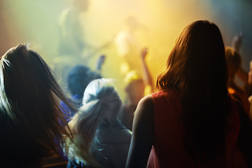 Image showing Music concert, crowd and people singing at night performance for gen z festival with party lights, dancing and cheers. Rock band on stage at event and crowd dance, audience rear or women fans