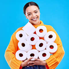 Image showing Toilet paper, young woman and portrait with happiness and smile in a studio. Isolated, blue background and happy female person and youth model with tissue rolls stock and gen z fashion smiling