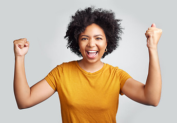 Image showing Portrait, winner and wow with a woman in studio on a gray background celebrating a victory or success. Motivation, smile and celebration with a happy young female model cheering her own achievement