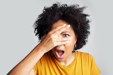 Image showing Surprise, wow and woman peeking through hand isolated on a white background in studio. Shocked, face and African female person shy, embarrassed or fear, scared or shame, emoji or mind blown portrait.