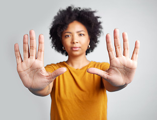 Image showing Portrait, hands and warning with a woman in studio on a gray background for control or to stop abuse. Palm, protest and body language with an attractive young female person saying no in disagreement