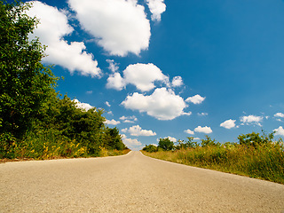 Image showing Countryside road, outdoor landscape and sky with clouds, summer sunshine and background in nature. Street, asphalt and spring with mockup space, trees and plants from low angle in natural environment