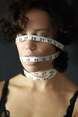 Image showing Mental health. a depressed young woman with tape around face and closed eyes. Depression, a person in a black or dark background and insecure about her body with measurements covering her head.