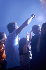 Image showing Man in crowd, fans and dancing at concert, music festival and hands in air for energy or night event. Dance, fun or group of excited people in arena at rock band performance or audience rave party.