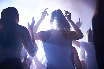 Image showing Concert, music festival and women from back, lighting and energy in crowd at live night event. Dance, fun and group of excited fans in arena at rock band performance or audience at techno rave party.