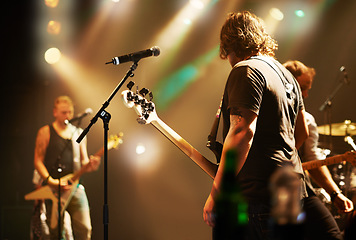 Image showing Performance, musician and men in a band at a concert for a music festival, event or show together. Night, stage and a group of people performing, singing and playing instruments at a club for a party