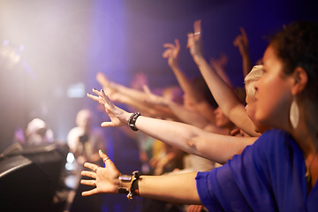 Image showing Fans in front row at concert, hands out and excited music festival audience at rock show. People in crowd at band performance at arena, stadium or party with happiness and energy at night stage event