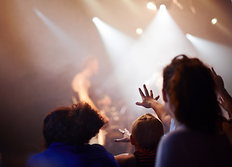 Image showing Hands, lighting and excited fans at music festival, crowd watching live band performance with musician on stage. Happiness, excitement and audience in arena, woman fans with hand out at rock concert.