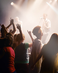 Image showing People dancing, concert and singing music at night performance, gen z band singer with lights and cheers. Musician on stage at event and youth dance, crowd of fans or women audience with hands in air
